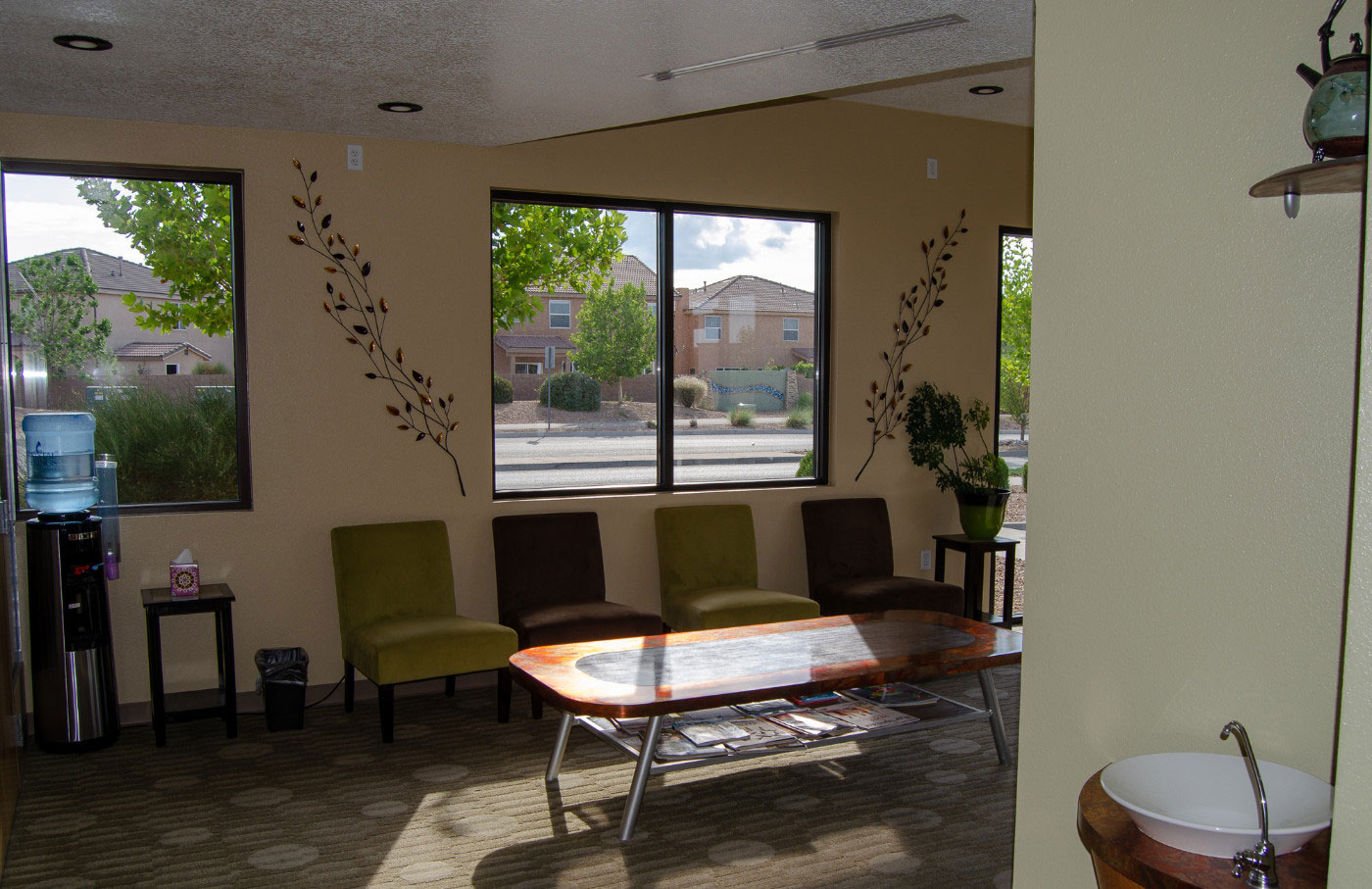 Waiting room with a modern design, featuring a large window, wooden furniture, and a contemporary decor.