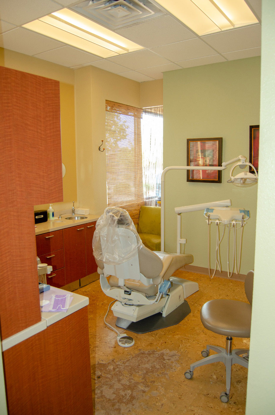 A dental office interior with a chair, desk, and open door.