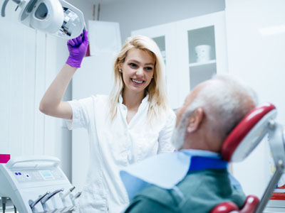 A dental hygienist is assisting a patient during a dental examination.