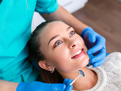 A dental professional performing a procedure on a patient in a dental office setting.